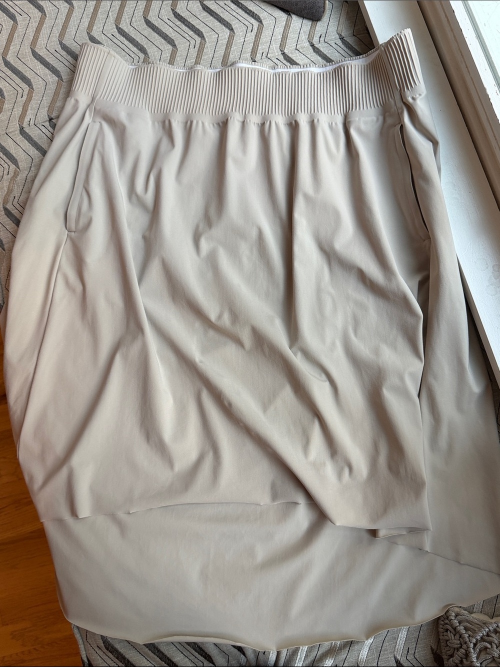 Athleta Cosmic high-low skirt in a cream or beige shade,